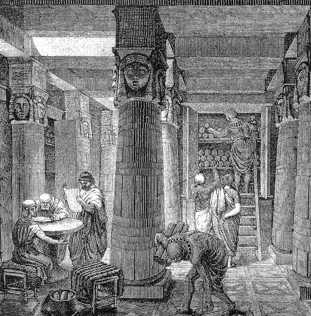 Grabado antiguo del interior de una gran biblioteca con columnas egipcias y estantes llenos de rollos de papiro, con sabios leyendo